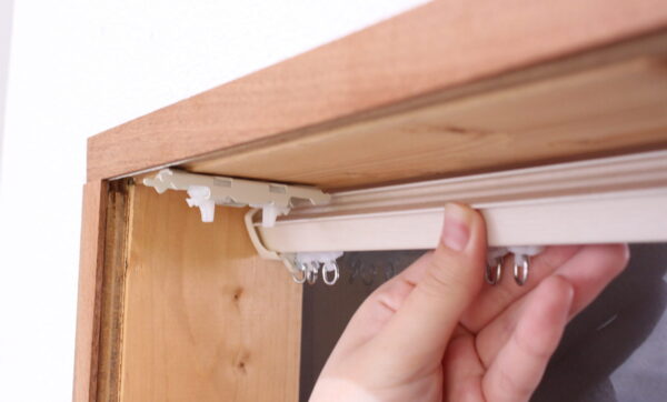 カーテンレールをブラケットにはめこむイメージ